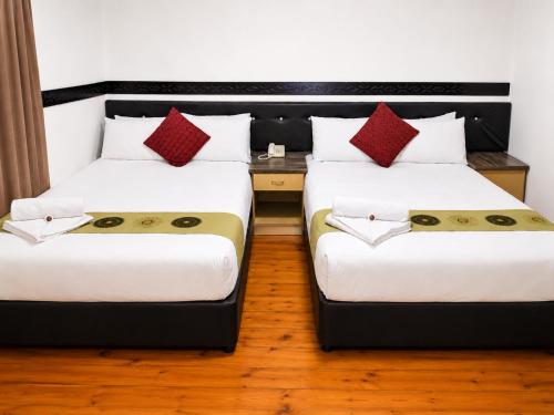 two beds sitting next to each other in a room at Laletsa Lodge in Durban
