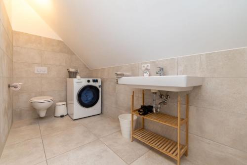 a bathroom with a sink and a washing machine at Kaiser's Hof in Strass