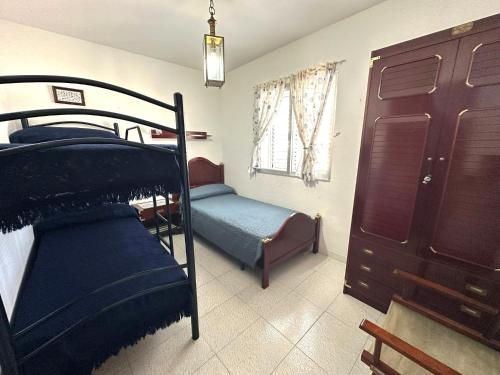 a bedroom with two bunk beds and a window at Adosado Mar i Pins in Benicarló