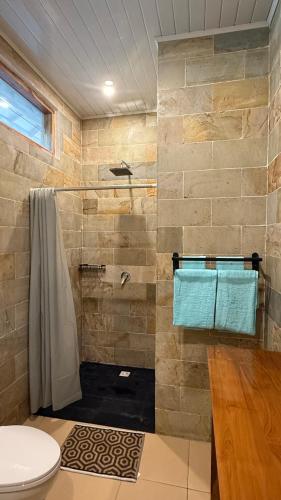 a bathroom with a shower and a toilet at The Tree Poolbar&Resort in Gili Islands