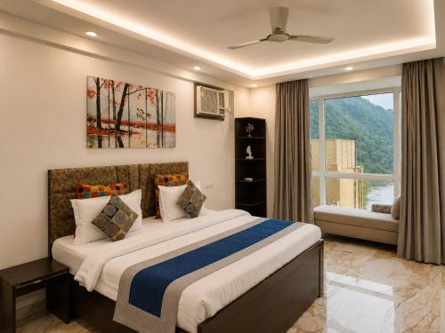a bedroom with a large bed and a window at Aloha Serenity By Evara -Ganga View Stays in Rishīkesh