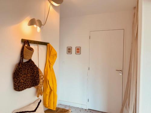 a room with a door and a yellow robe on a wall at Gigi La Roza in Perros-Guirec