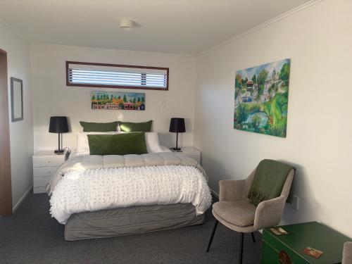 a bedroom with a large bed and a chair at Gone Potty 1 in Alexandra
