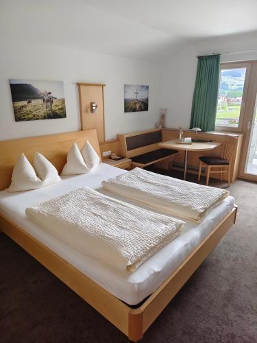 a hotel room with a large bed and a table at Appartements Bergsonne in Westendorf