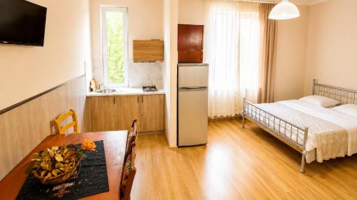 a kitchen with a table and a refrigerator in a room at Tuz House R6 in Bakuriani