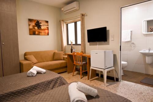 a room with two beds and a living room at Sharon Court Guesthouse in St. Paul's Bay