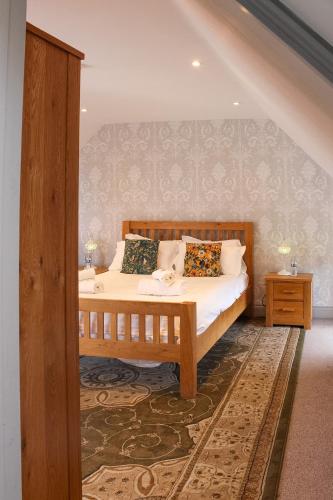 a bedroom with a wooden bed with pillows on it at The Selsey Arms in West Dean