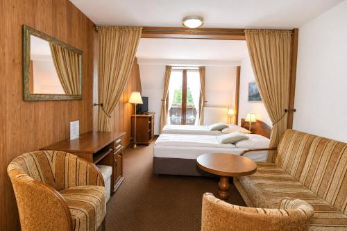 a hotel room with a bed and a table and chairs at Penzión Encián in Tatranská Lomnica