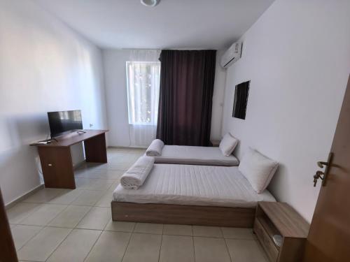 a bedroom with a bed and a desk in it at Стаи за гости Ескейп in Isperikh