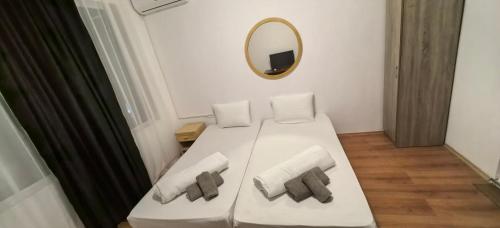 a white bed with two pillows and a mirror at Стаи за гости Ескейп in Isperikh