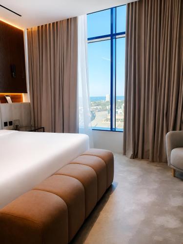 a hotel room with a bed and a large window at Bloom Hotel-Kuwait in Kuwait