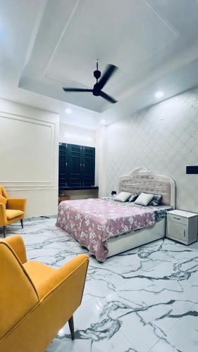 a bedroom with a bed and a ceiling fan at Mannat Villa Homestay in Rāmnagar