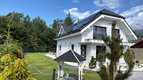 a white house with a black roof at Villa White Stone in Starý Smokovec