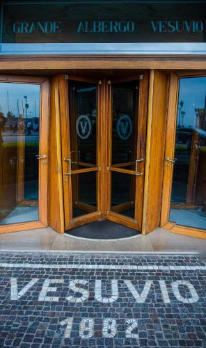 a sign in front of a building with two doors at Grand Hotel Vesuvio in Naples