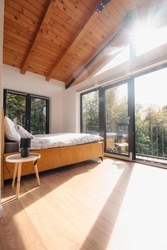 a bedroom with a bed and large windows at Casa Vinea in Karlovac