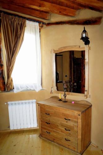 a room with a dresser with a mirror and a window at Eco Village Under the Cliffs in Ilindentsi