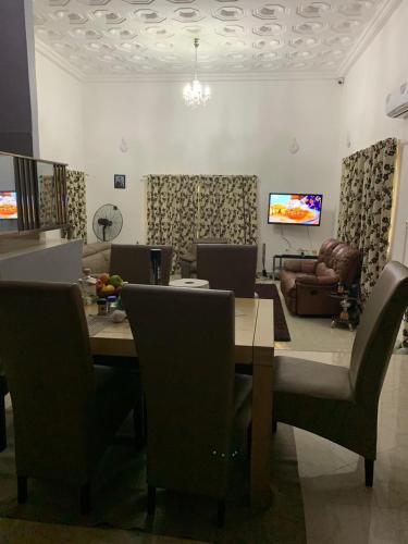 a dining room with a table and chairs and a couch at FREDJACKSAIR BNb in Koforidua