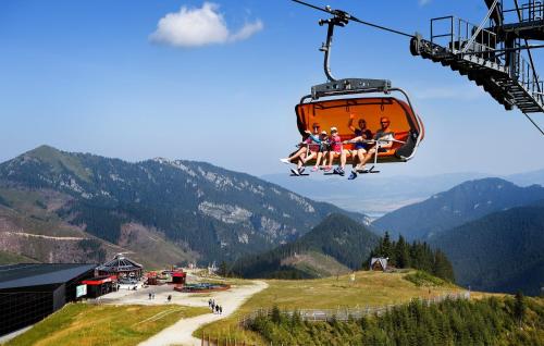 a group of people sitting on a ski lift at Hotel Liptov in Belá
