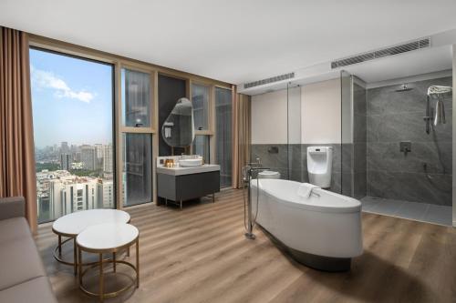 a bathroom with a tub and a sink and a table at Epic Tower Swiss-Belresidences Hanoi in Hanoi
