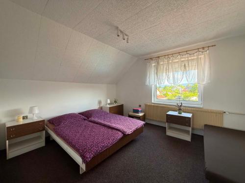 a bedroom with a purple bed and a window at Pension Barborka in Jičín