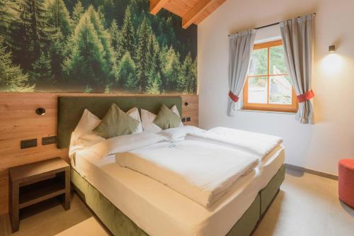 a bedroom with a large bed with a painting on the wall at Vidor Resort in Pozza di Fassa
