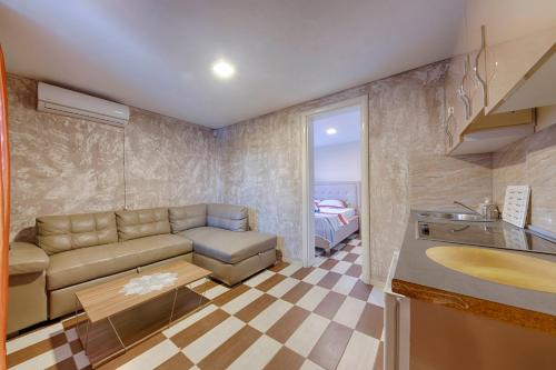 a living room with a couch and a table at ZIS LUX Apartments Pool in Utjeha