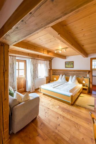 a bedroom with a large bed and a couch at Schmiedlehnerhof in Birnberg