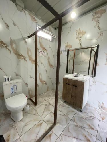 a bathroom with a toilet and a sink and a mirror at Karakol Yurt Village in Karakol