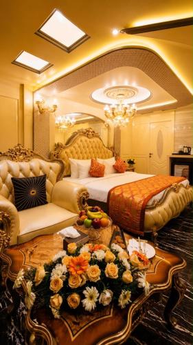a large bedroom with two beds and a table with flowers at Hotel Park Elanza Coimbatore in Coimbatore