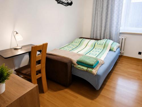 a small bedroom with a bed and a desk at Mieszkanie Warka in Warka