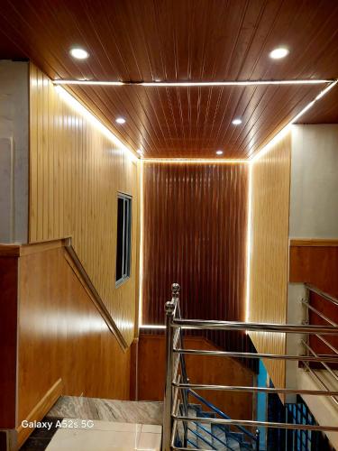 a staircase in a room with a wooden wall at Hotel Swagat in Itahari