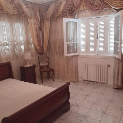 a bedroom with a bed and a chair and windows at Rejiche in Rejiche