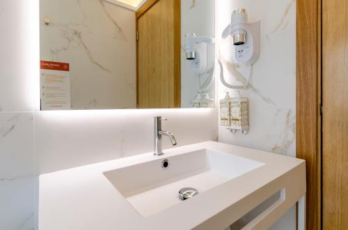 a bathroom with a white sink and a mirror at Ouro Rossio Hotel in Lisbon