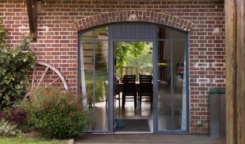 an entrance to a brick building with a glass door at LA HAUTE FORGE - Maison d'hôtes in Thoiré-sur-Dinan