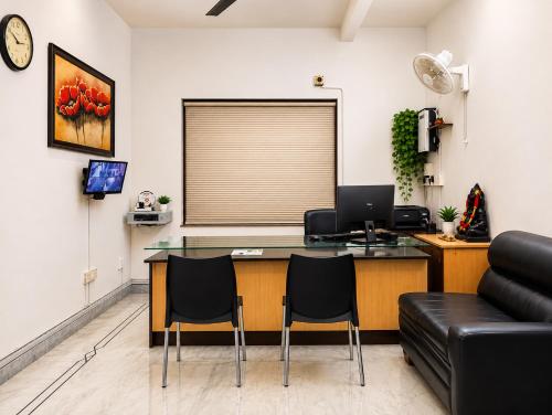 an office with a desk with a computer and chairs at Next Generation Guest House in kolkata
