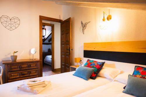 a bedroom with a large white bed with blue pillows at Apartamentos Nevandi in Pido
