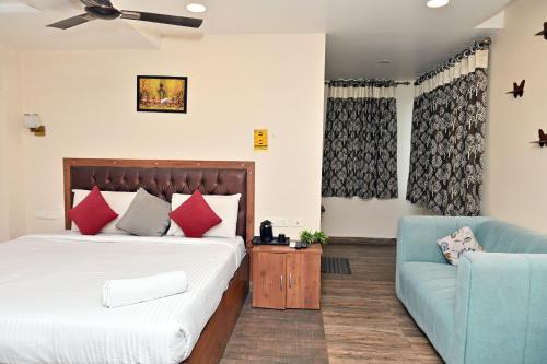 a bedroom with a bed and a blue couch at Hotel Ganesh Mahalakshmi Inn in Guntūr