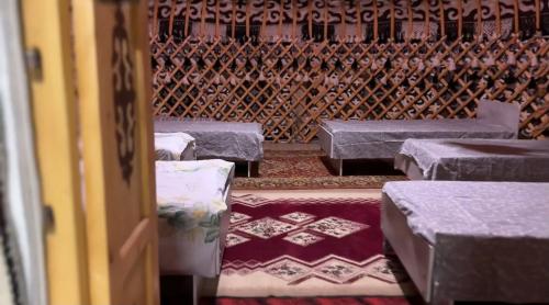 a room with rows of tables and a wooden wall at Bars guest House in Barskoon