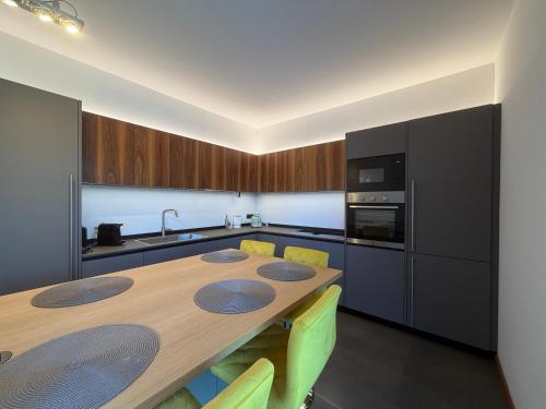 a kitchen with a wooden table with yellow chairs at Prestigiosa vista lago in Como