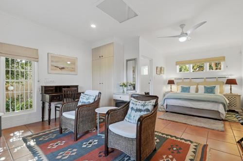a bedroom with a bed and a desk with a piano at Paradiso Guesthouse & Self-catering Cottage in Cape Town