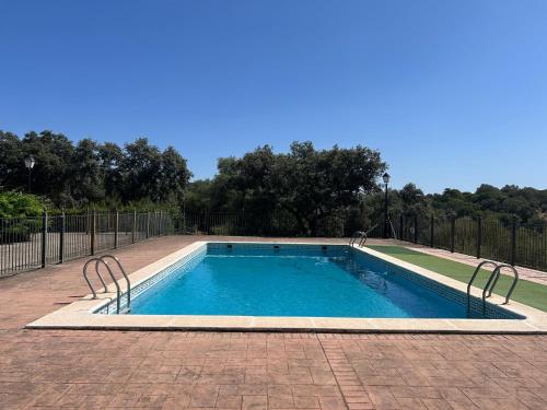 a swimming pool in a yard with a fence at Finca Los Majadales in Almodóvar del Río