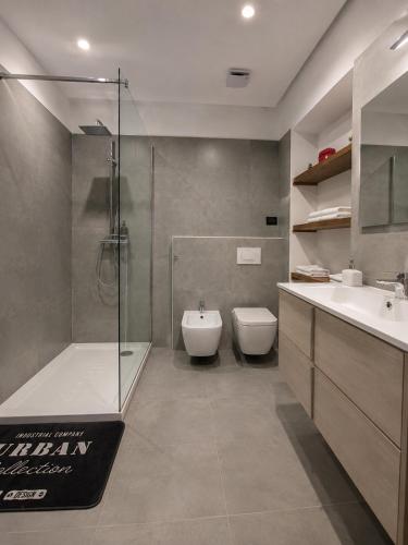 a bathroom with a shower and a toilet and a sink at Novi Outlet Apartment in Novi Ligure