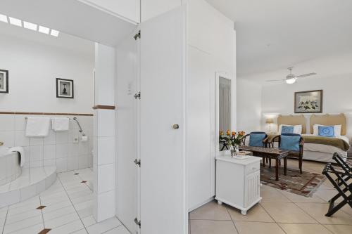 a bathroom with a tub and a bedroom with a bed at Paradiso Guesthouse & Self-catering Cottage in Cape Town