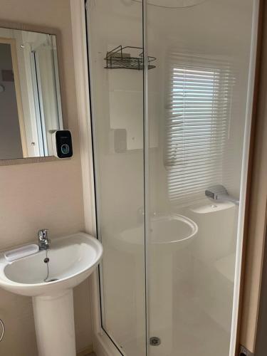 a bathroom with a glass shower and a sink at Mon nid douillet in Valras-Plage