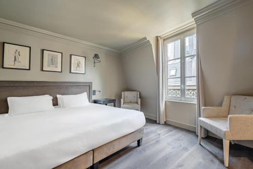 a bedroom with a large bed and a chair at Hôtel Villa d'Estrées - Saint-Germain in Paris