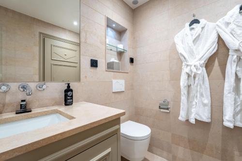 a bathroom with a sink and a toilet and a mirror at Hôtel Villa d'Estrées - Saint-Germain in Paris