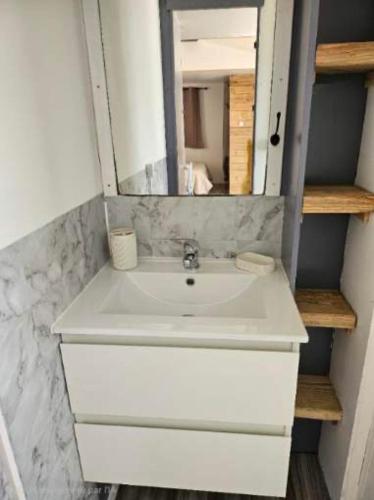 a white sink in a bathroom with a mirror at Le cocon & spa in Camaret-sur-Aigues