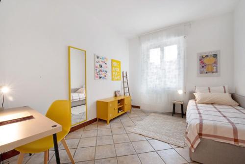 a bedroom with a bed and a desk and a table at Maddy's House in Mandello del Lario