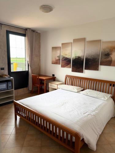 a bedroom with a large bed and a table at Agriturismo Terra Del Mare in Fossalòn