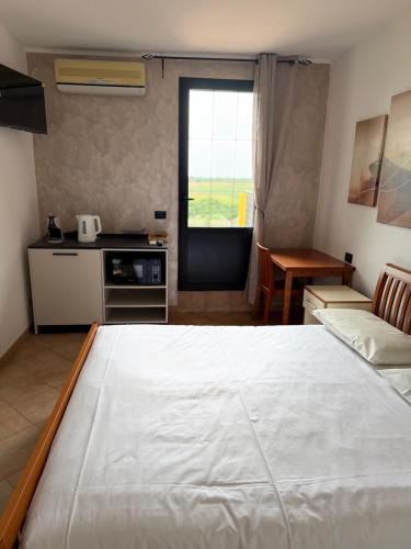 a large white bed in a room with a kitchen at Agriturismo Terra Del Mare in Fossalòn